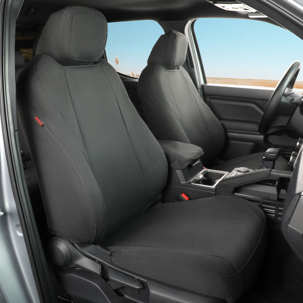 Canvas Black car seat covers installed on the front seats of a vehicle interior, shown with the door open and dashboard visible.