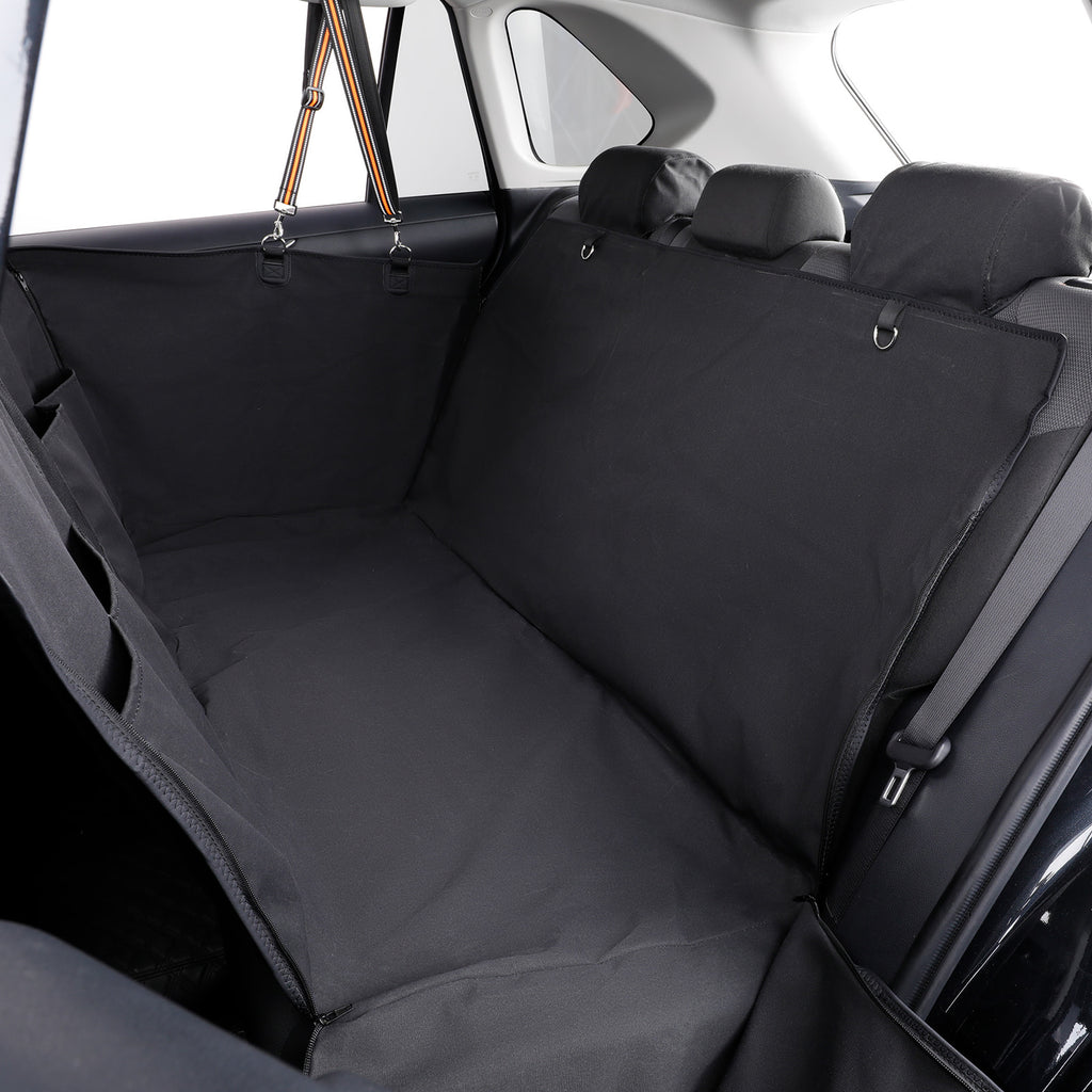 A black car cargo liner installed in the trunk area of a vehicle, shown behind the rear seats with headrests visible and the interior car door and window in the background.