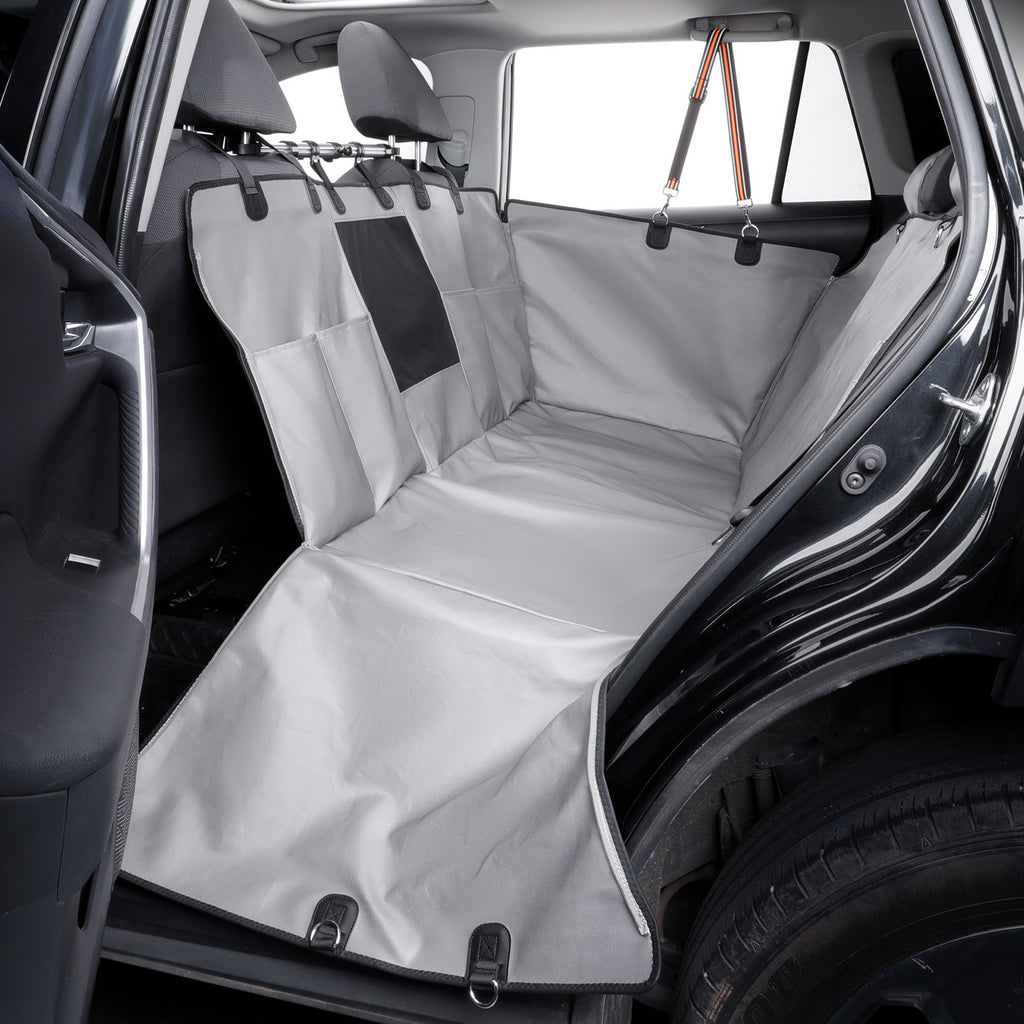 A light gray car interior cargo liner and seat cover set installed in the back of a vehicle, protecting the seat and floor from wear and dirt.