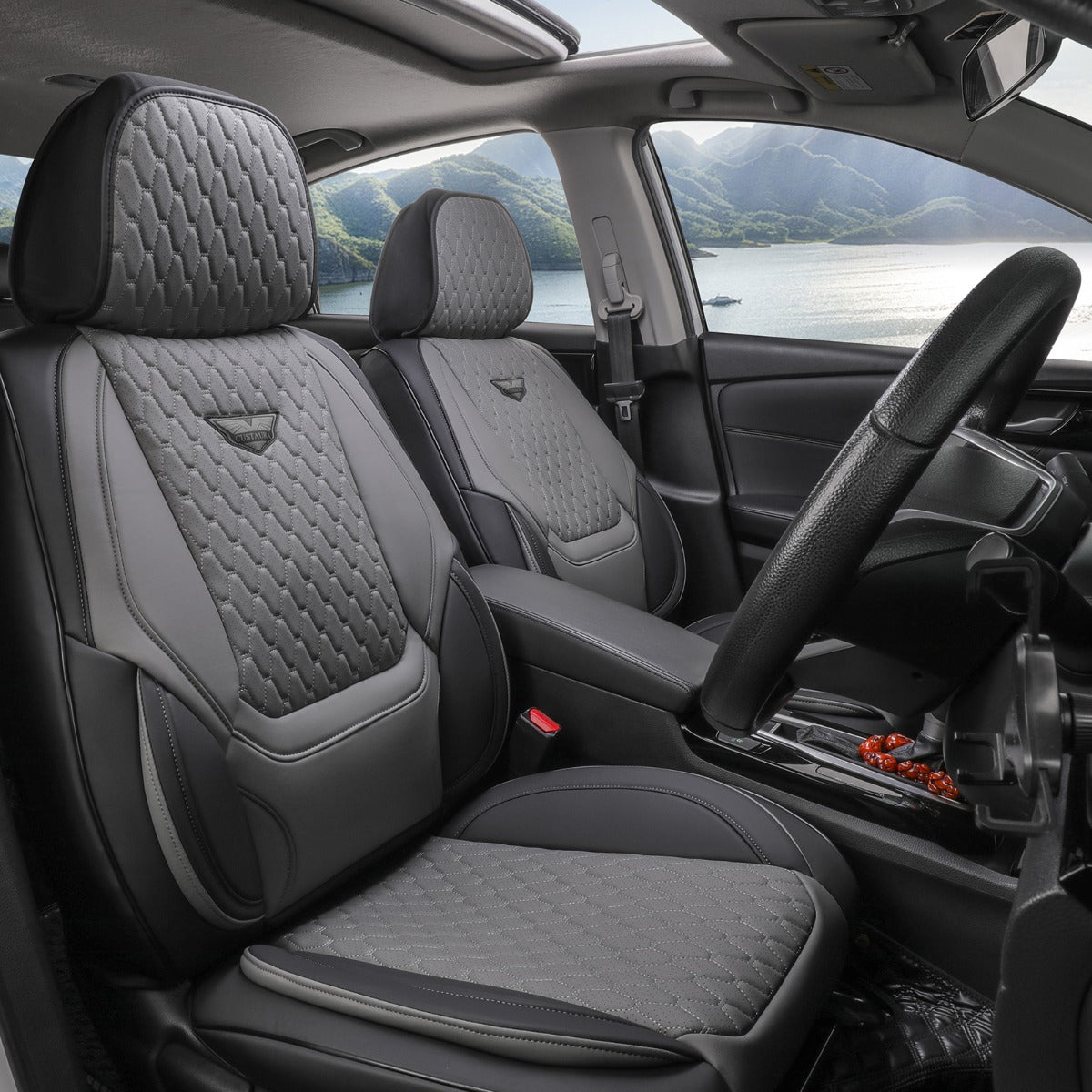 Car interior with gray quilted seat covers and a scenic view outside the window.