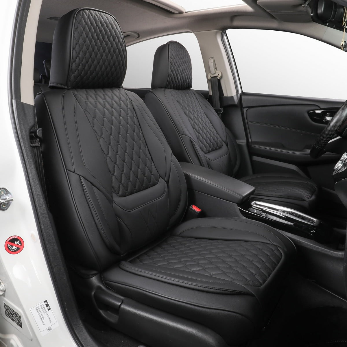 Black car seat covers with diamond-quilted stitching installed on the front seats of a vehicle interior.