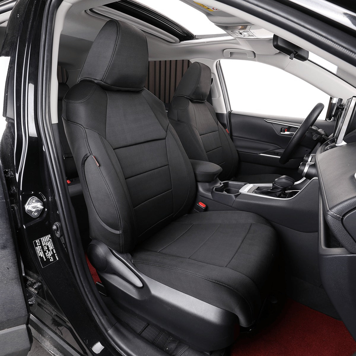 Black car seat covers installed on the front seats of a vehicle interior, shown with the door open to display the fit and finish.