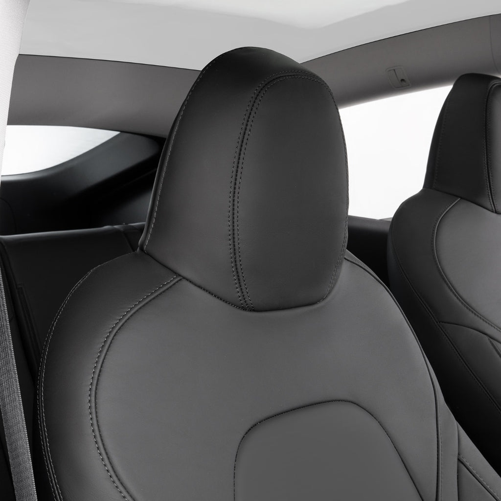 Black leather car seat headrest and part of the seat back with visible stitching, photographed inside a vehicle cabin.