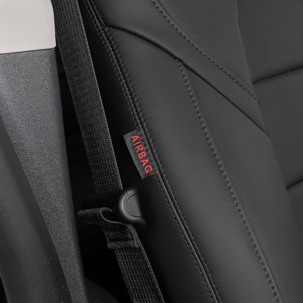 Close-up of a black car seat with a black seatbelt and a small fabric tag reading AIRBAG in red text.