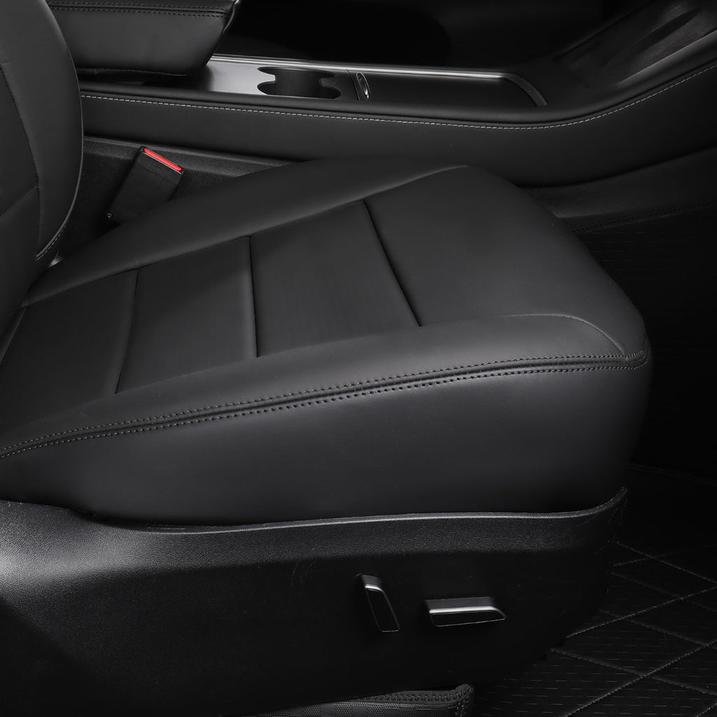 Black leather car seat cushion with stitched panel detailing, shown installed inside a vehicle interior next to the door panel.