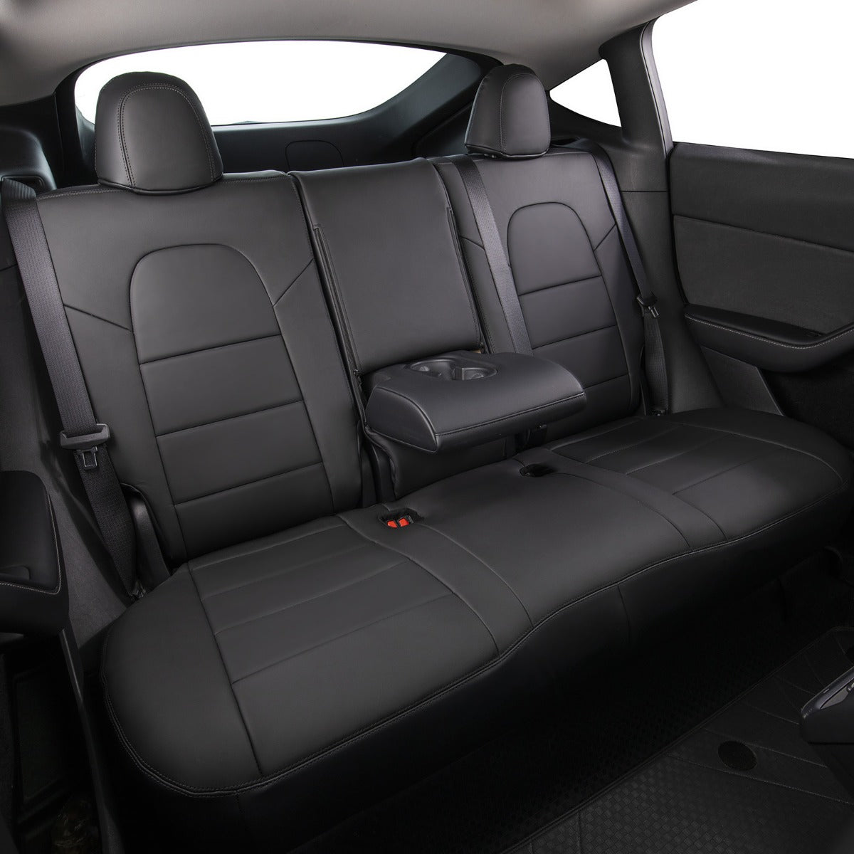 Black leather car rear seat bench with integrated center armrest and headrests, shown inside a vehicle cabin.