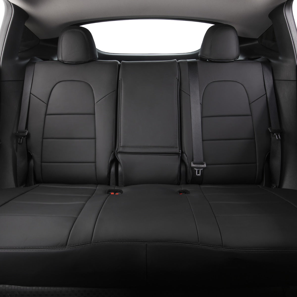 Black leather car rear seat bench with integrated headrests and seatbelts, shown from the front-facing rear cargo area.