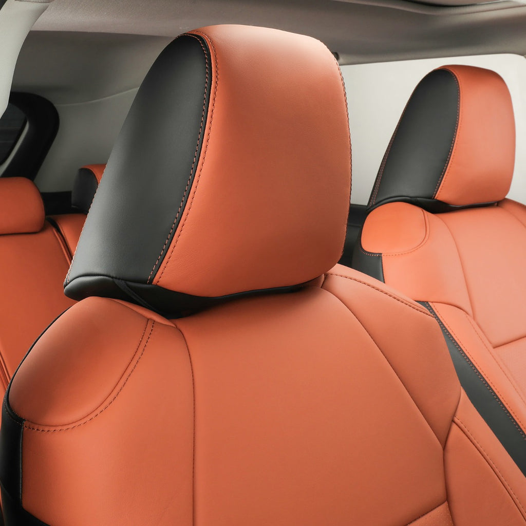 Brown and black leather car seat covers installed on the front seats of a vehicle interior.