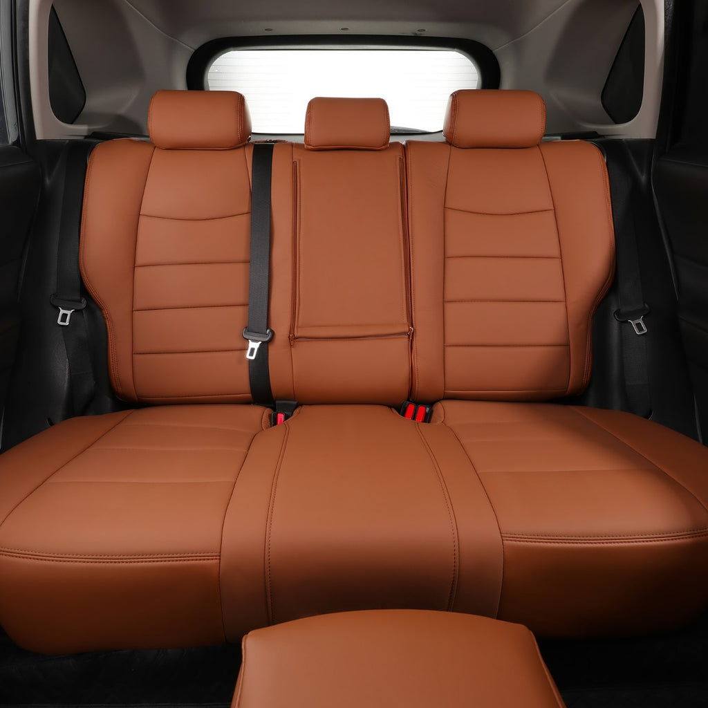 Brown leather car seat covers installed on a three-seat rear bench and front footwell area inside a vehicle, shown from the rear interior.