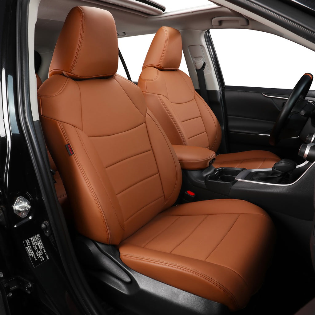 Brown leather car seat covers installed on the front seats of a vehicle interior, shown from the open driver-side door.