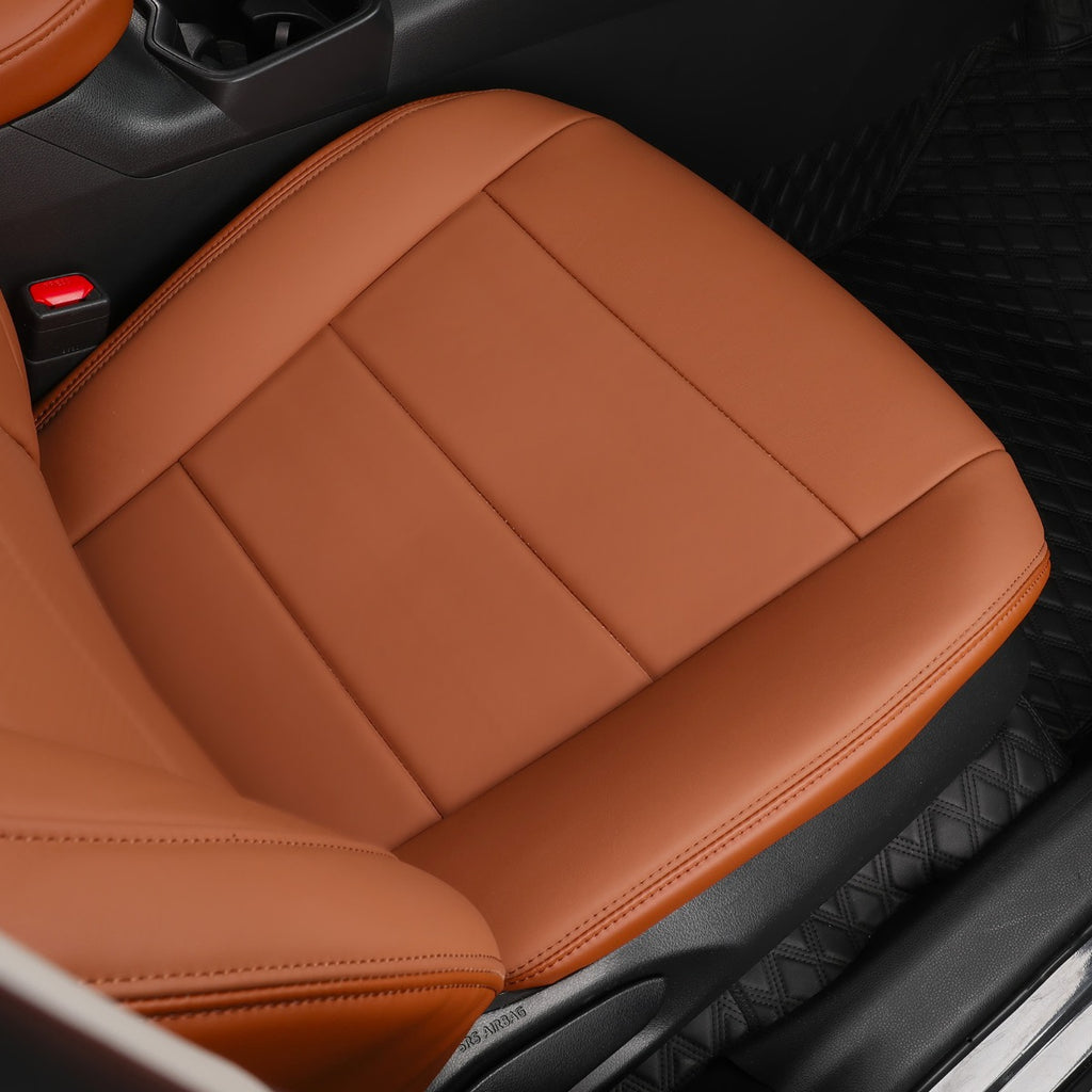 A close-up of a car front seat cover in a warm tan-brown color, fitted over the seat inside a vehicle.
