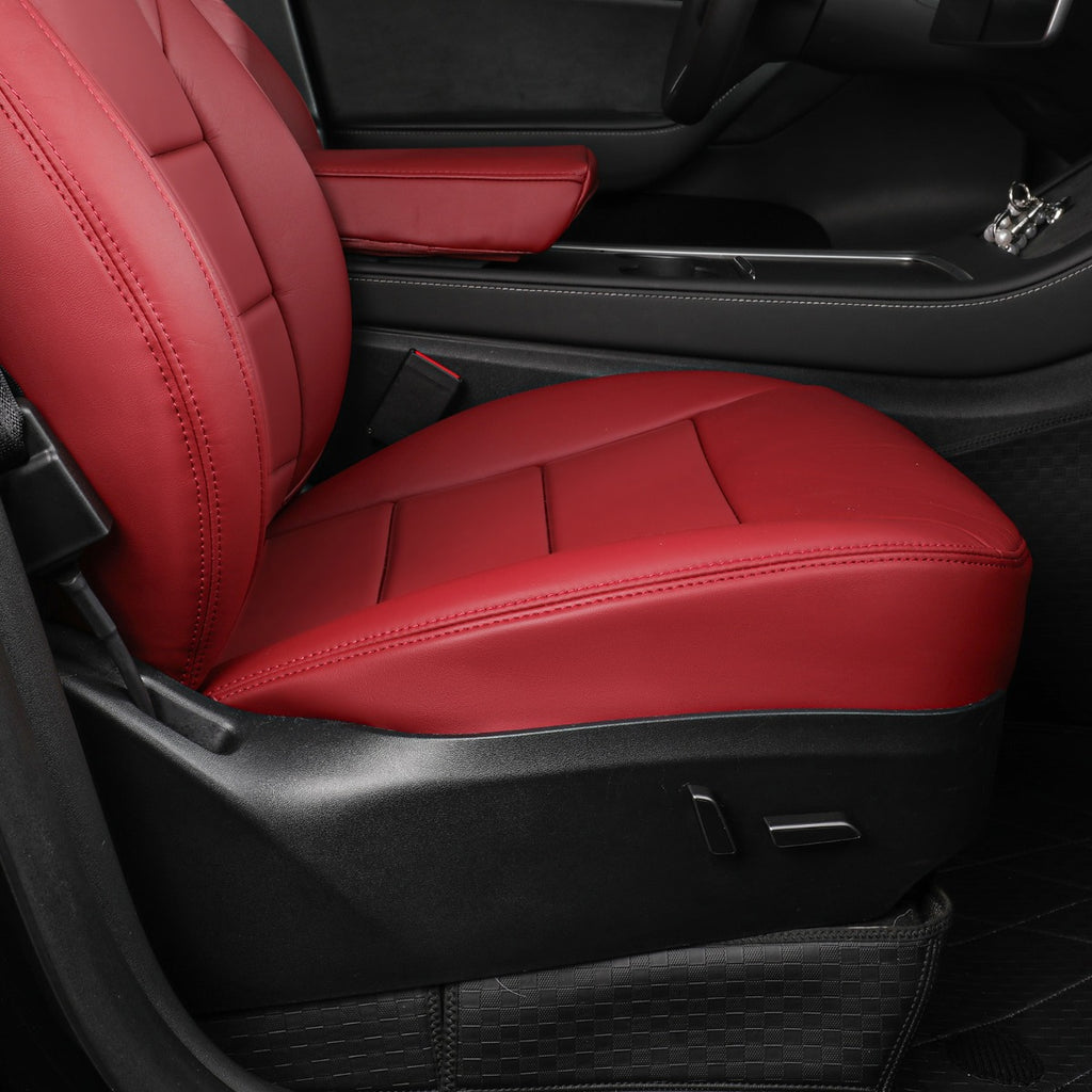 A pair of burgundy car seat covers installed on the front passenger and driver seats inside a black car interior.