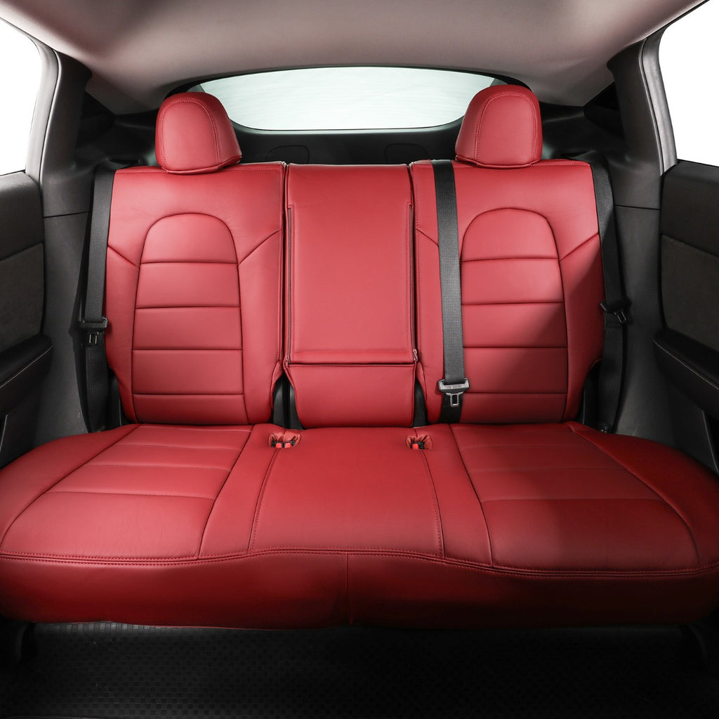 A set of burgundy leather car seat covers installed on the rear bench of a vehicle, shown from the back looking forward. The red covers fit snugly over the red car seats, with black seatbelts visible.