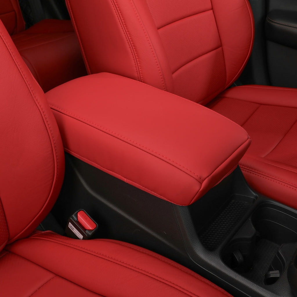 Red car seat covers installed on the front seats and center console armrest of a vehicle interior.