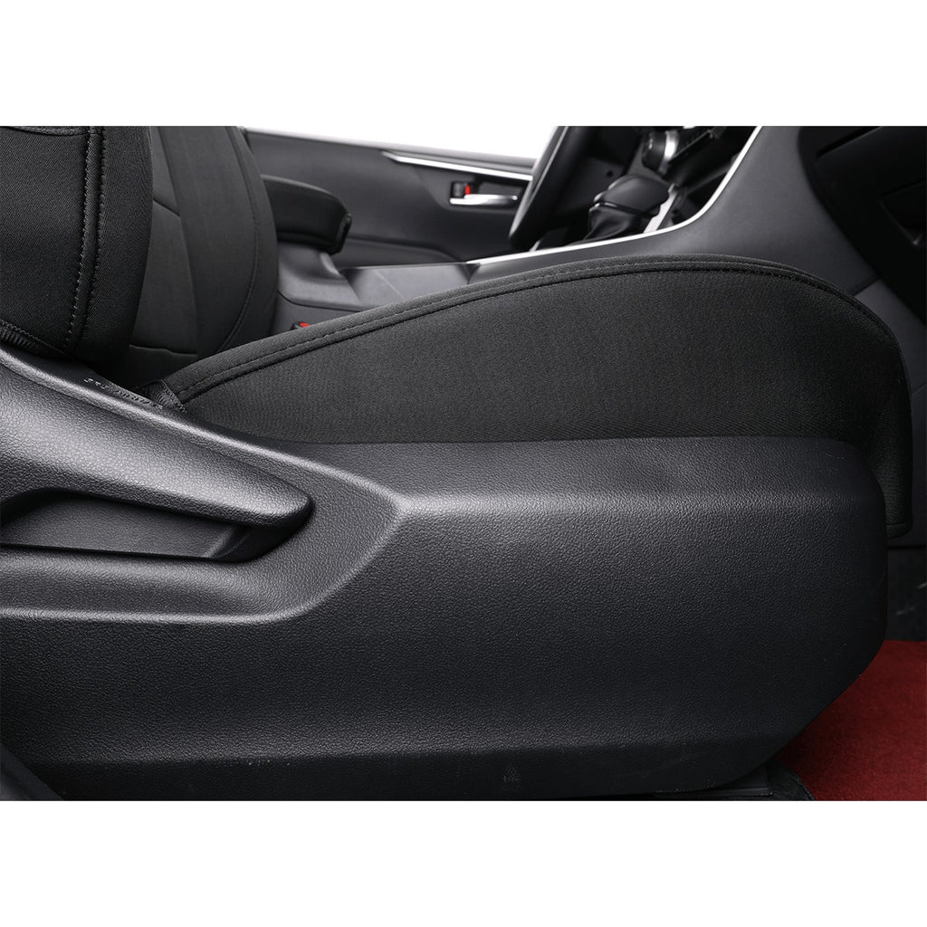 A close-up of a black car interior showing a textured seat cover installed on the front passenger seat, with the center console and steering wheel visible in the background.