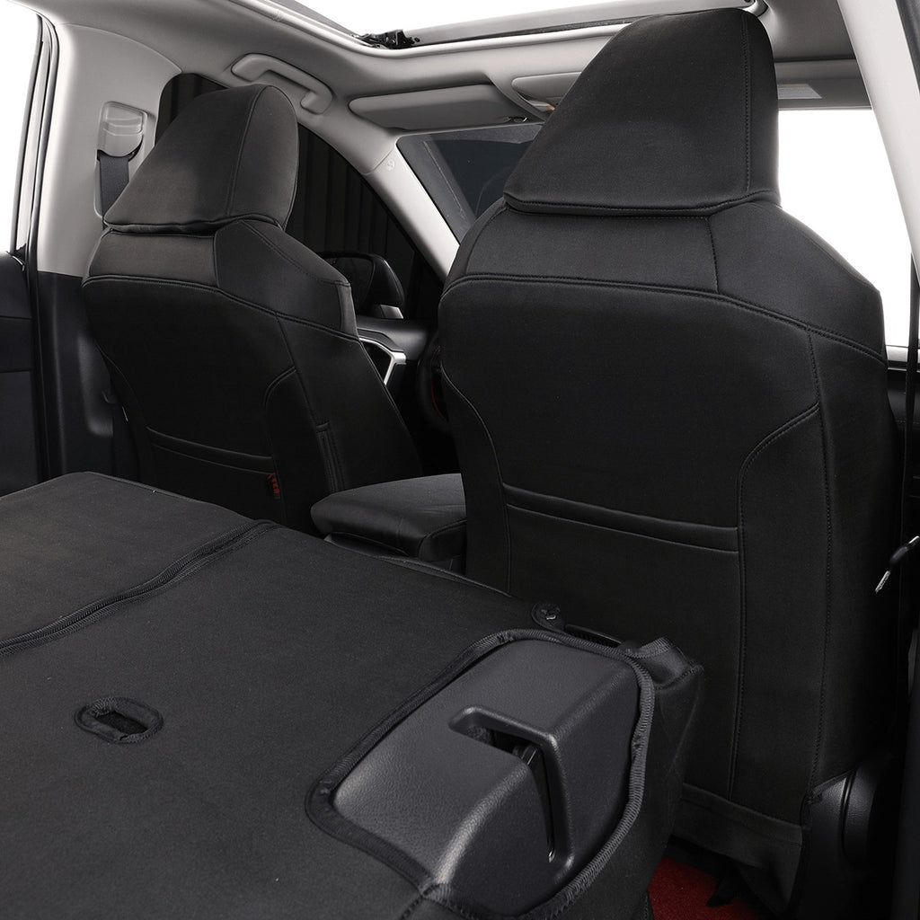 Black car seat covers installed on the front and rear seats of a vehicle interior, shown with the trunk folded down.