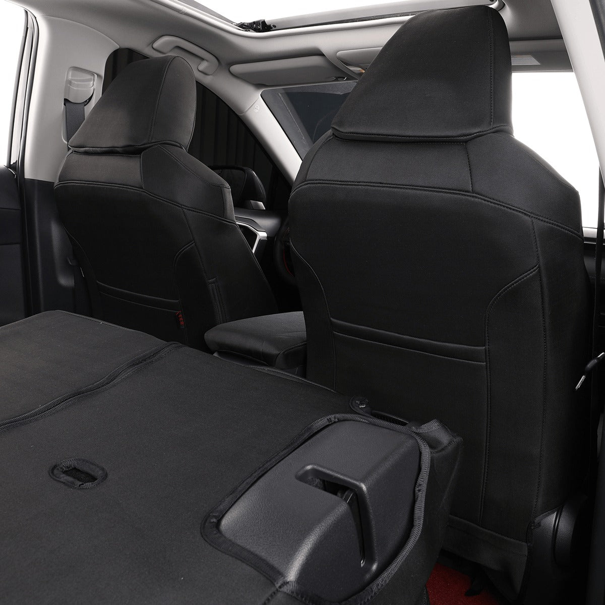 Black car seat covers installed on the front and rear seats of a vehicle interior, shown with the trunk folded down.