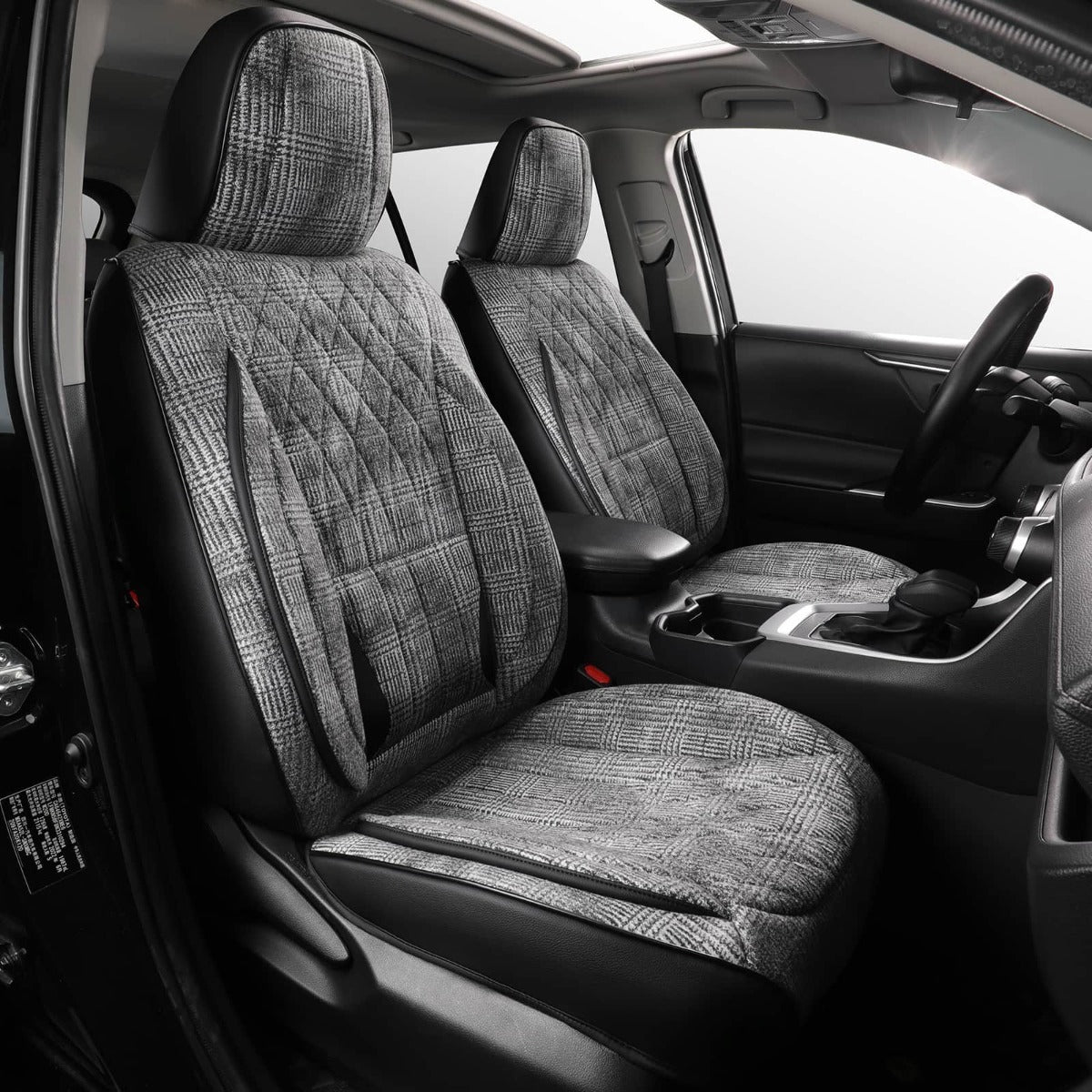 A pair of gray and black plaid car seat covers installed on the front seats of a vehicle interior.